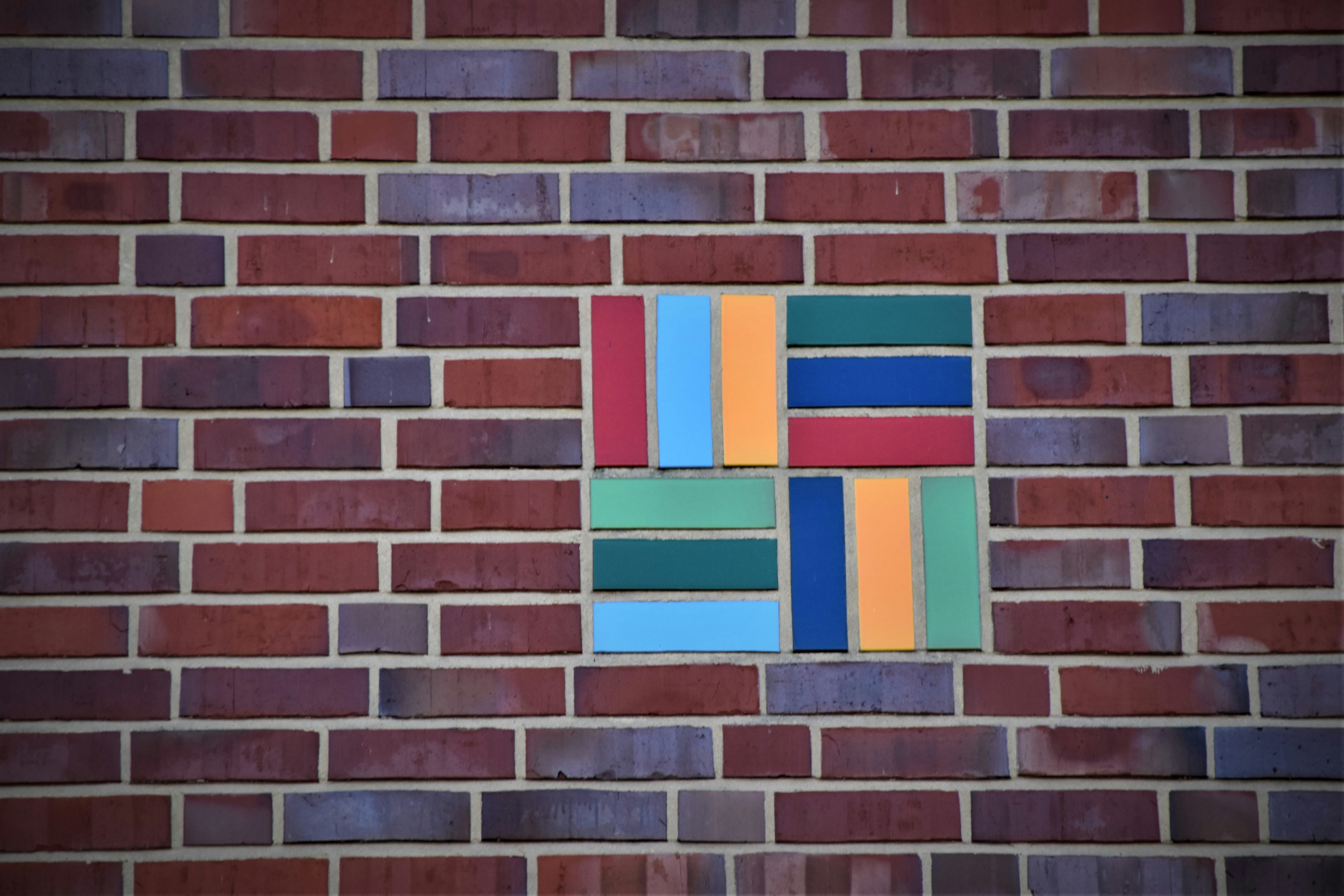 brown brick wall with blue red and yellow windows