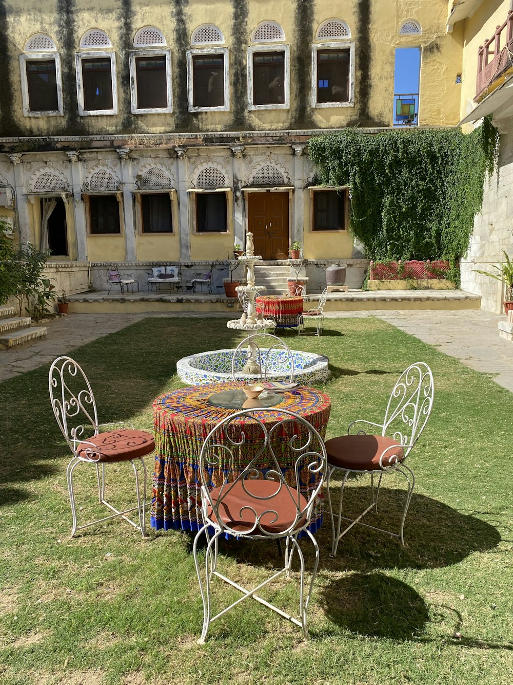 red and white metal chairs and round table on green grass field