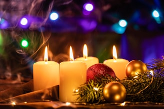 Close-up of a beautifully lit Advent wreath with candles and festive ornaments.