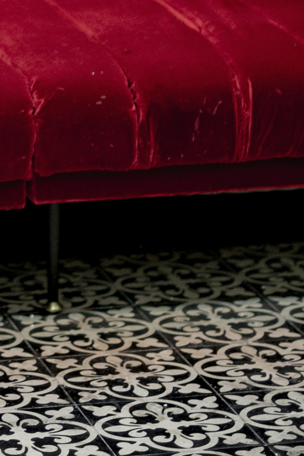 sofá de couro vermelho no chão preto e branco