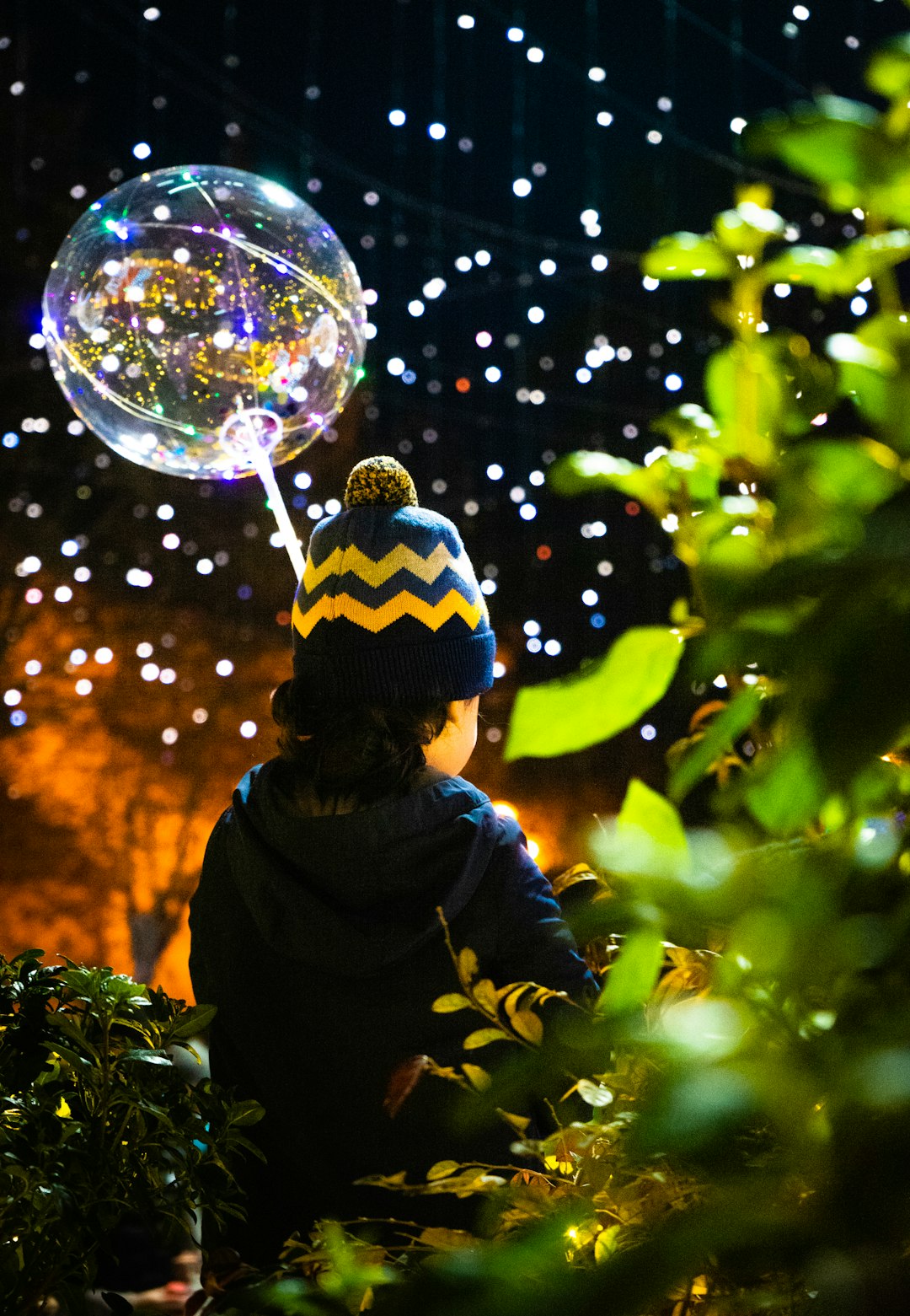 person in black and white knit cap and black jacket looking at the bubble