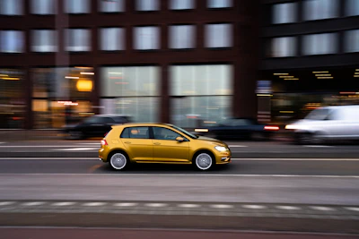 Bright yellow moving truck driving through a busy urban area in Mexico City.
