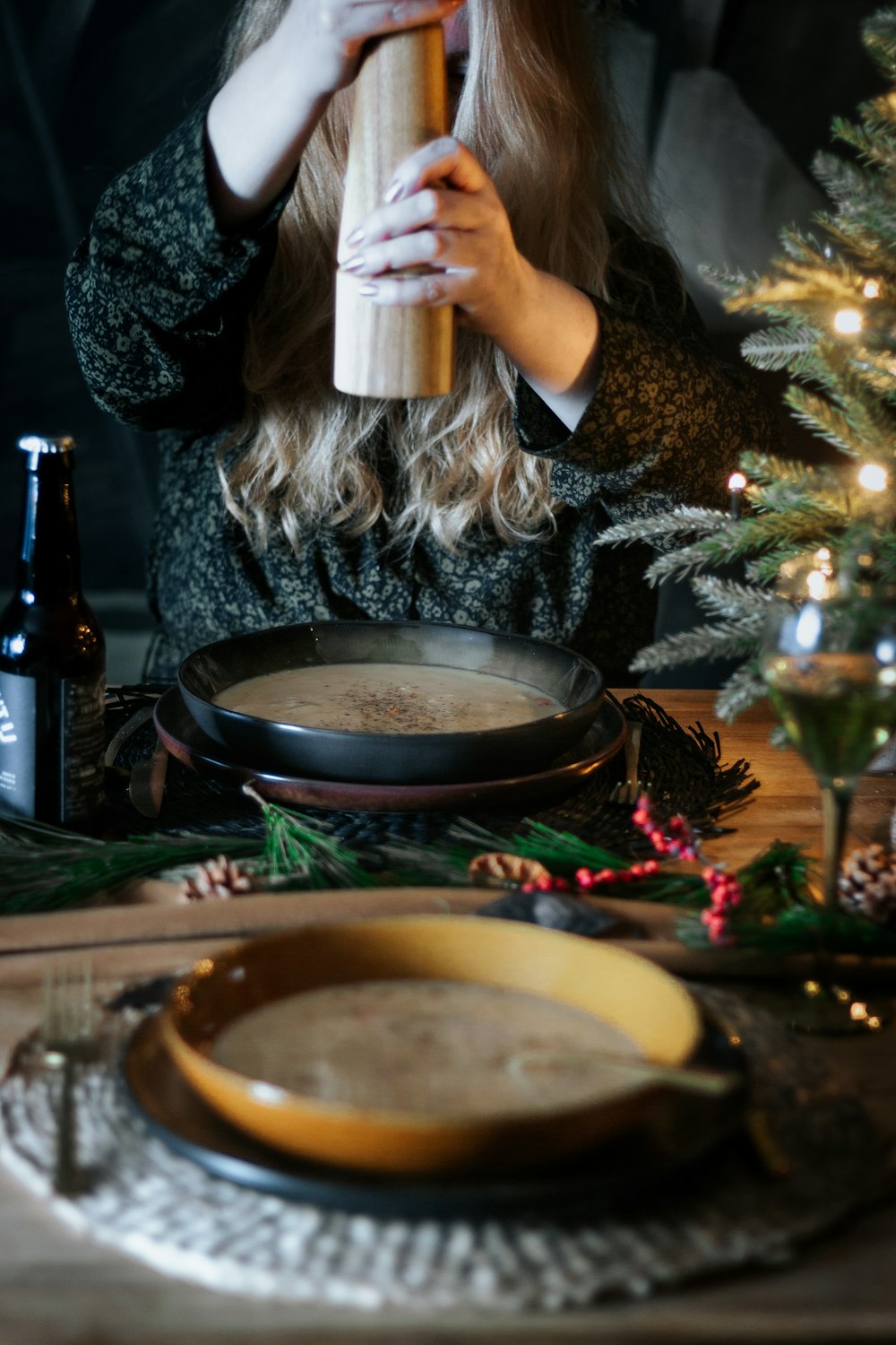 Femme en chemise fleurie noire et blanche tenant une tasse en céramique blanche