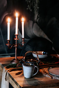 A cozy dining table set with warm earthenware, cardamom pods, and flickering candles, inviting guests to an intimate meal.