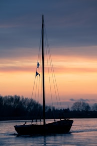 Close-up of sails catching the warm evening breeze against a colorful sky.
