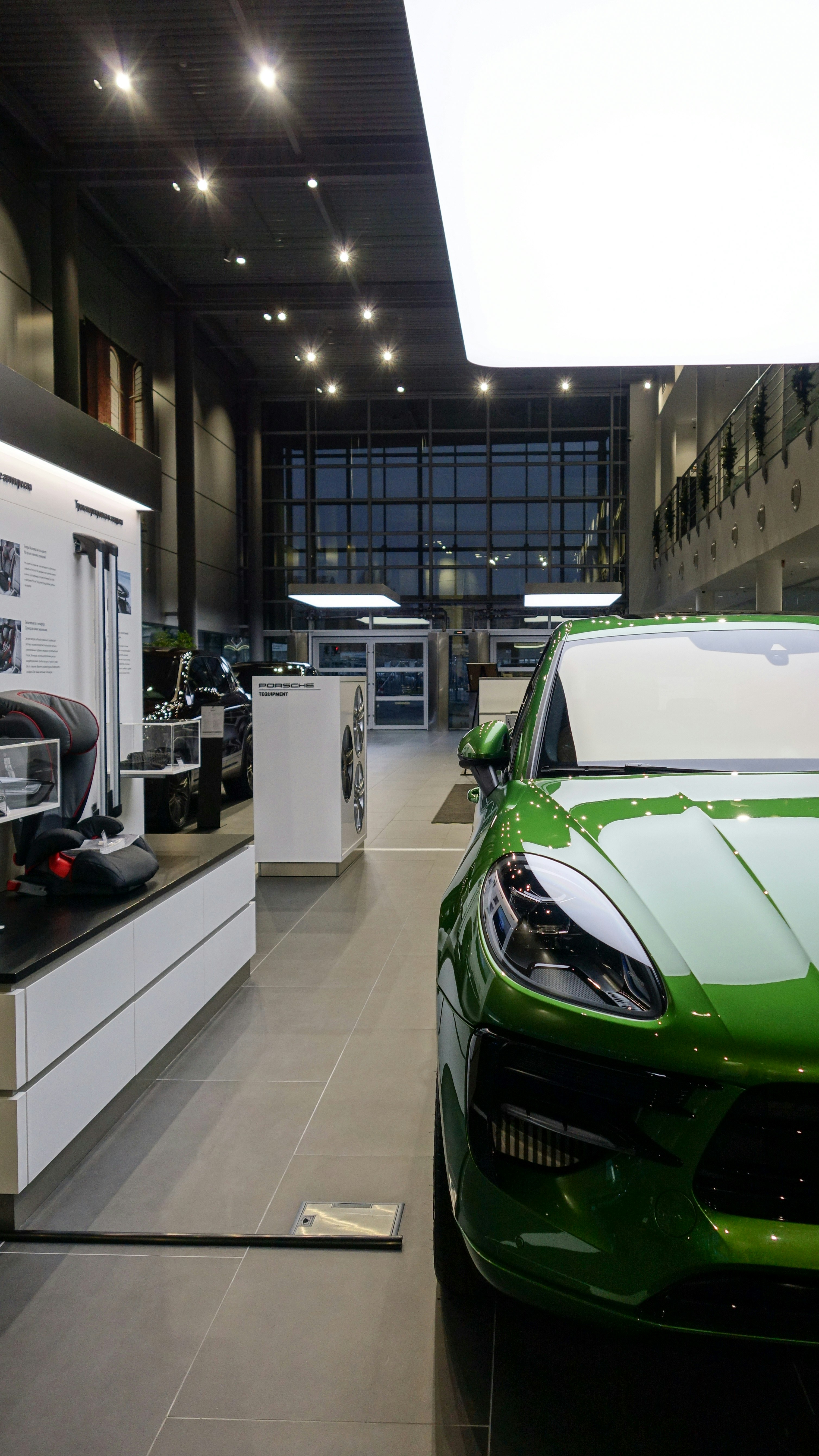 Bright green luxury SUV parked inside a modern car dealership.