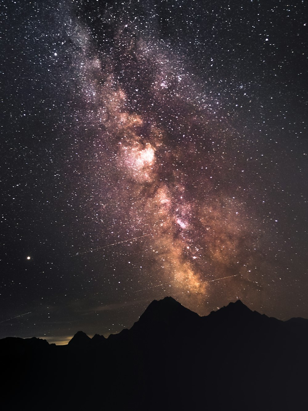 silhouette of mountain under starry night