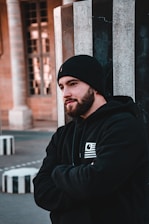man in black hoodie wearing black knit cap