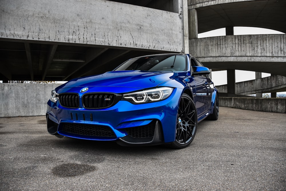 blue bmw m 3 coupe parked on gray concrete floor during daytime
