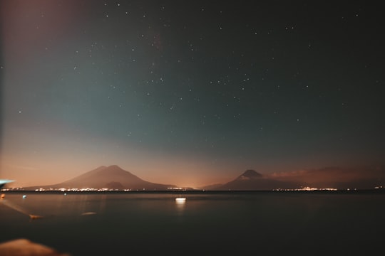 body of water near mountain during night time in Panajachel Guatemala