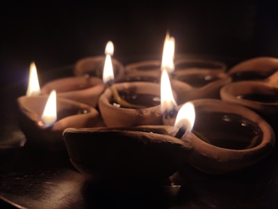 Handcrafted Panchagavya cowdung diyas glowing warmly on a rustic wooden surface.