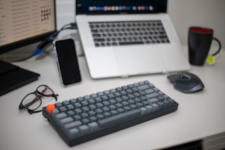 black computer keyboard beside black smartphone