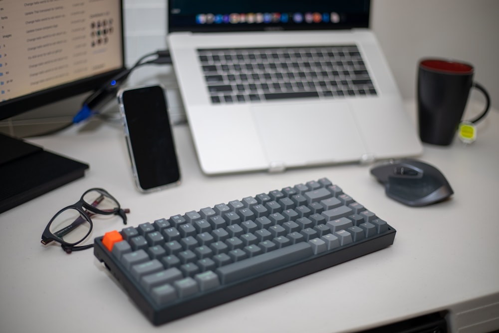 black computer keyboard beside black smartphone