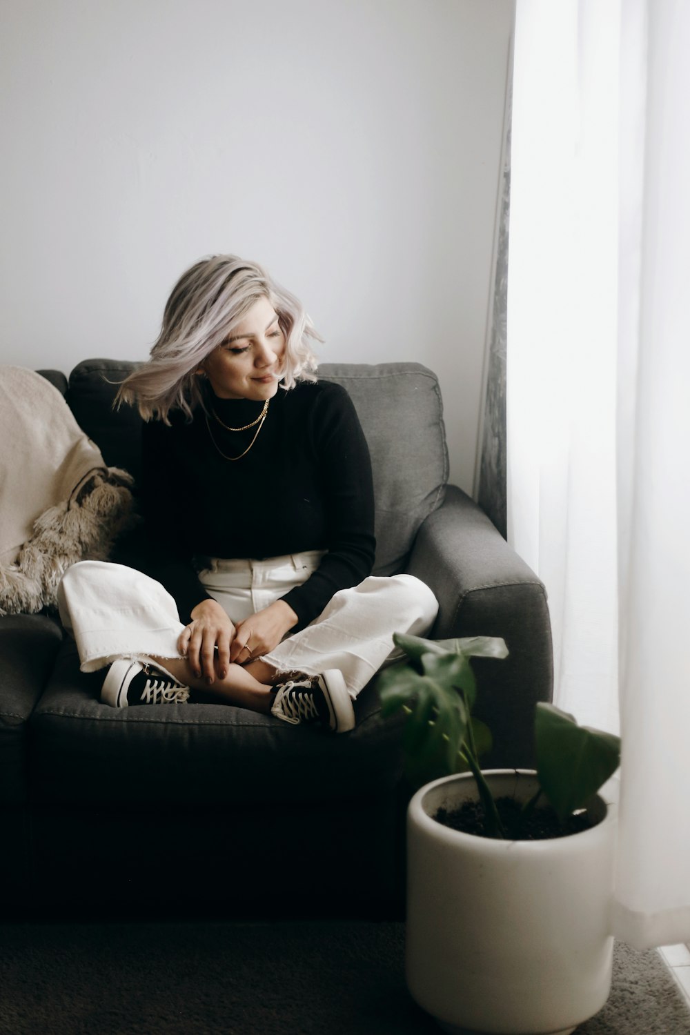 woman in black long sleeve shirt sitting on gray couch