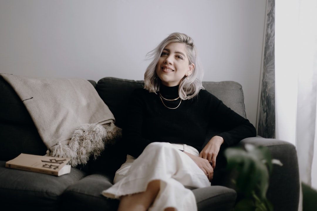 woman in black long sleeve shirt sitting on black sofa