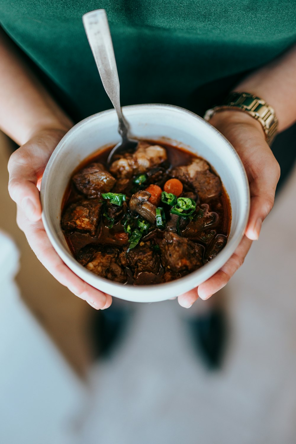 Person mit weißer Keramikschüssel mit Suppe