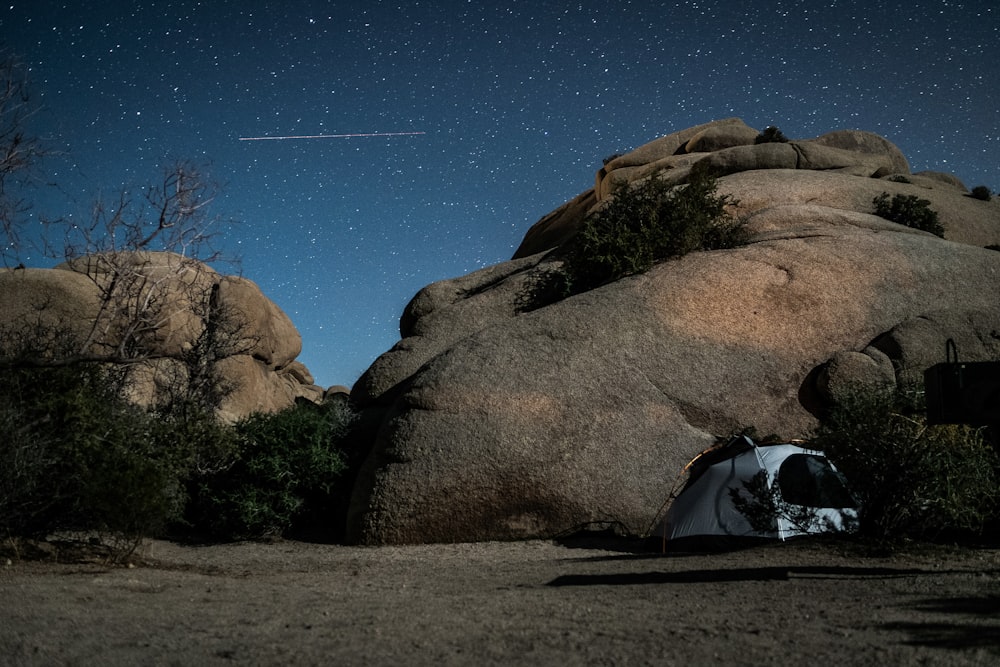 white and blue dome tent on brown rock formation under blue sky during daytime