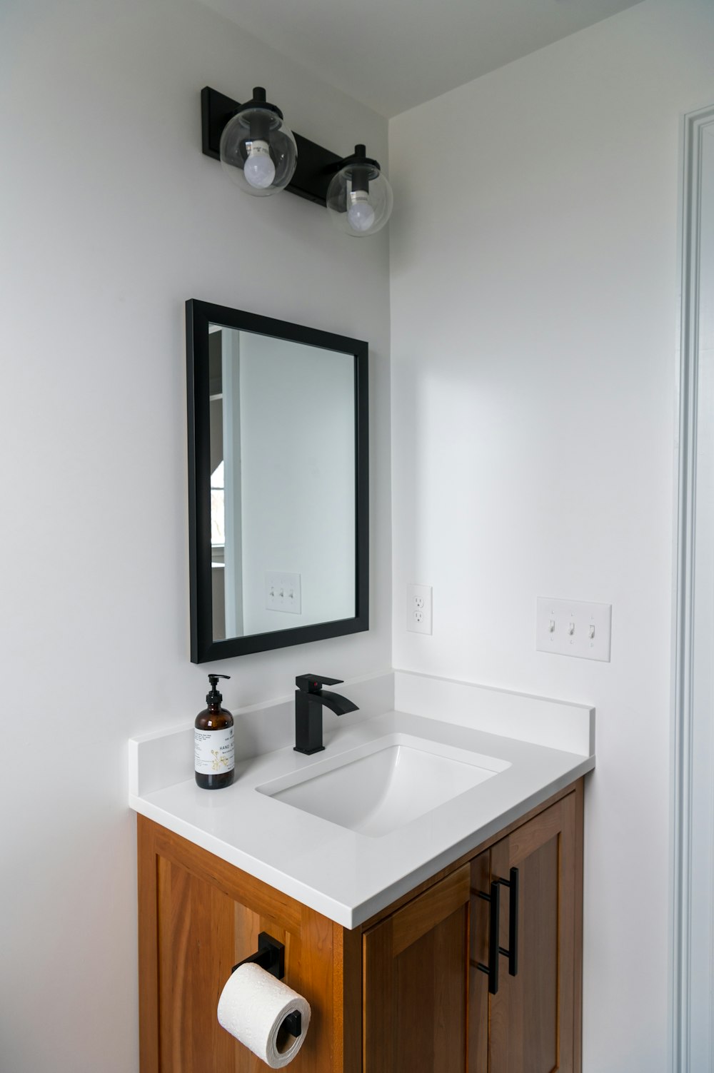 black framed mirror on white wall