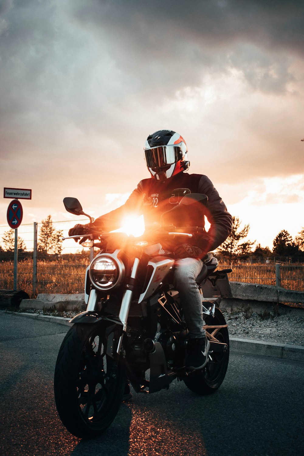 man in red motorcycle helmet riding motorcycle during sunset