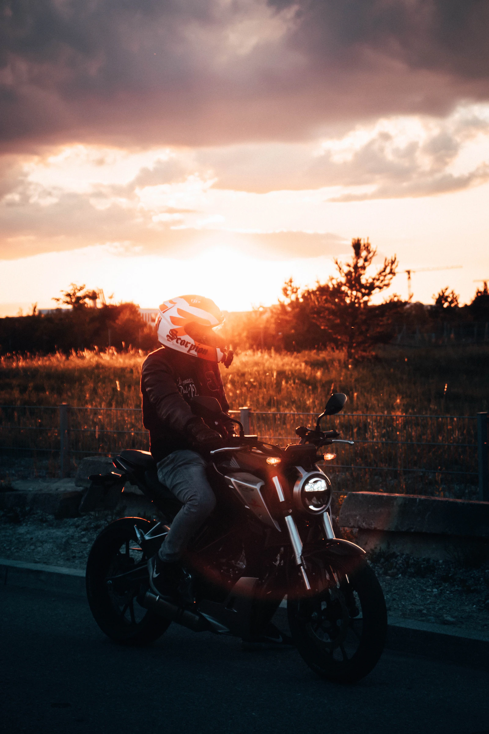 Motard en blouson noir au coucher du soleil — physique du 2 roues et dynamique de conduite