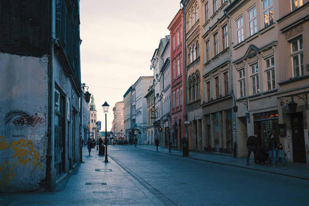 people walking on sidewalk between buildings during daytime