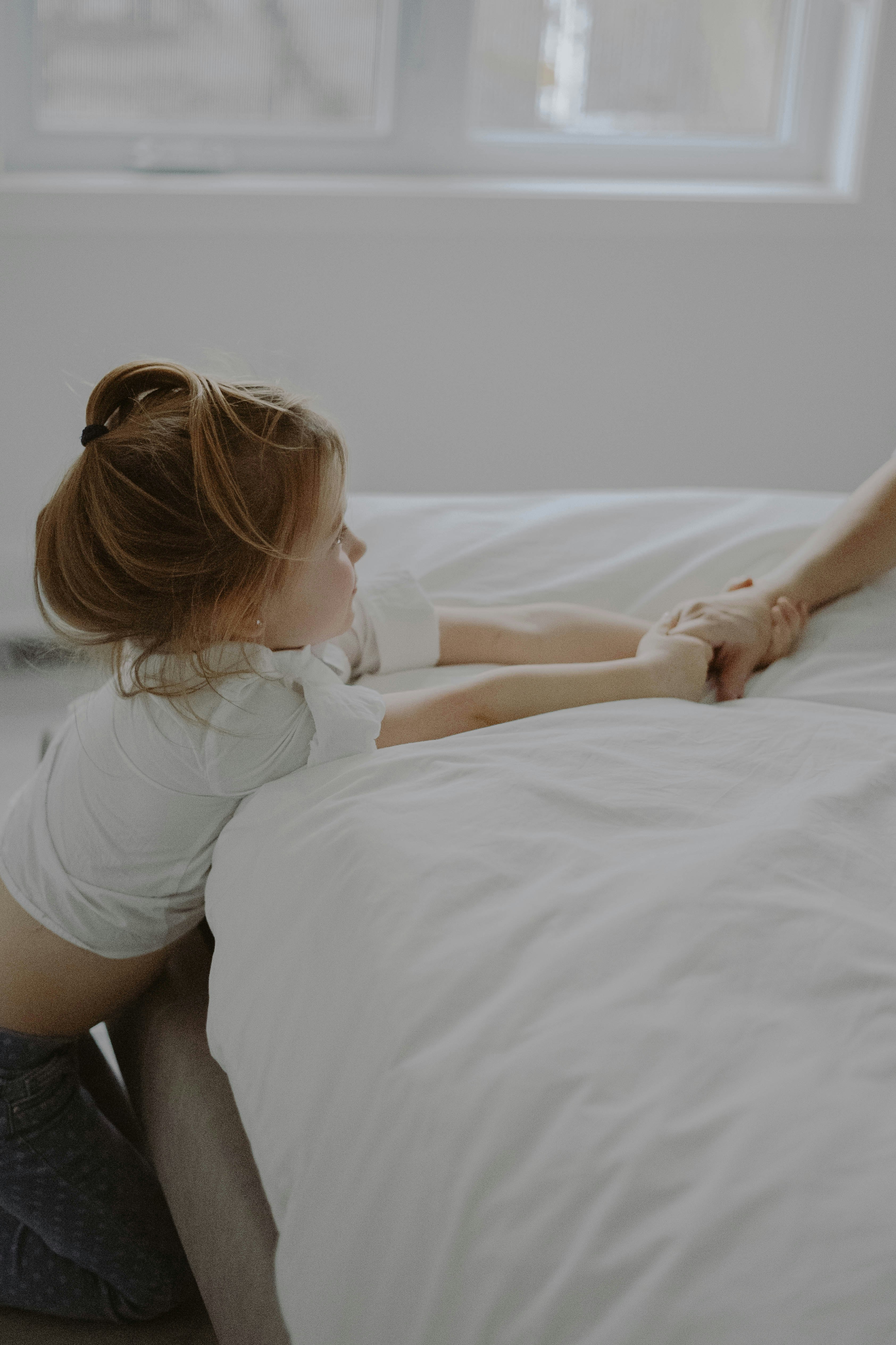 woman in white t-shirt lying on bed