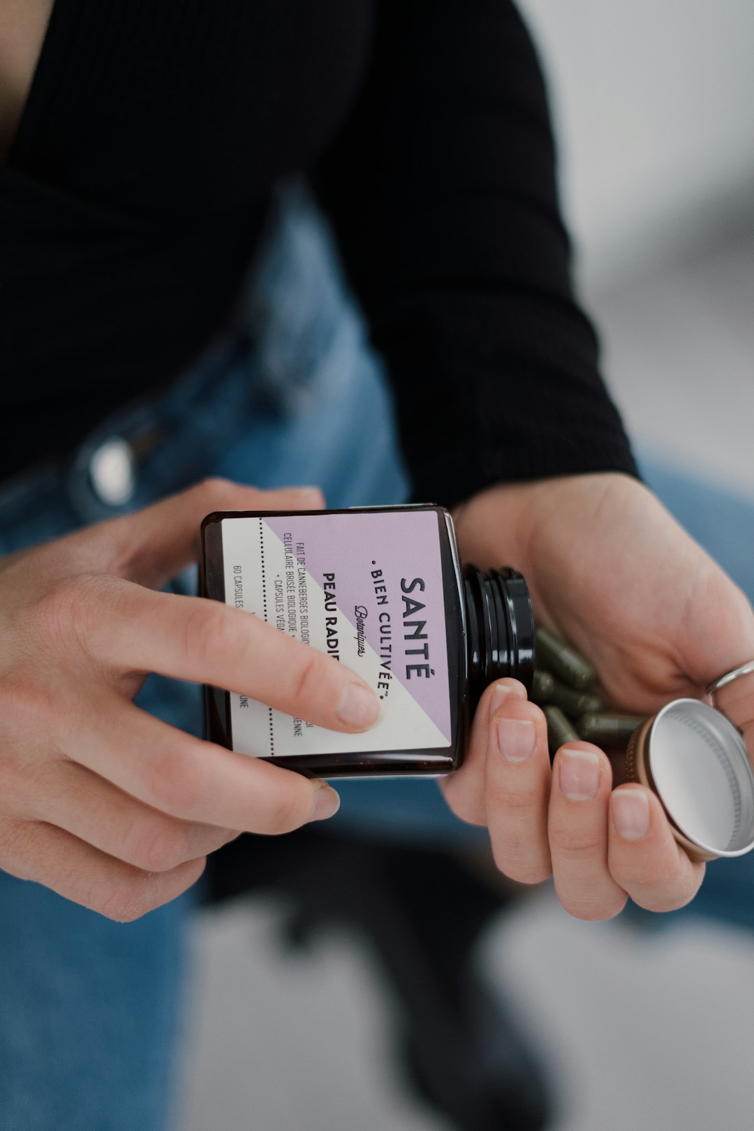 person holding black and white labeled bottle