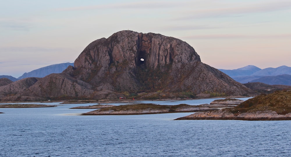 brown rock formation on sea water under white sky during daytime