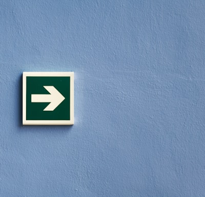 white and green arrow sign