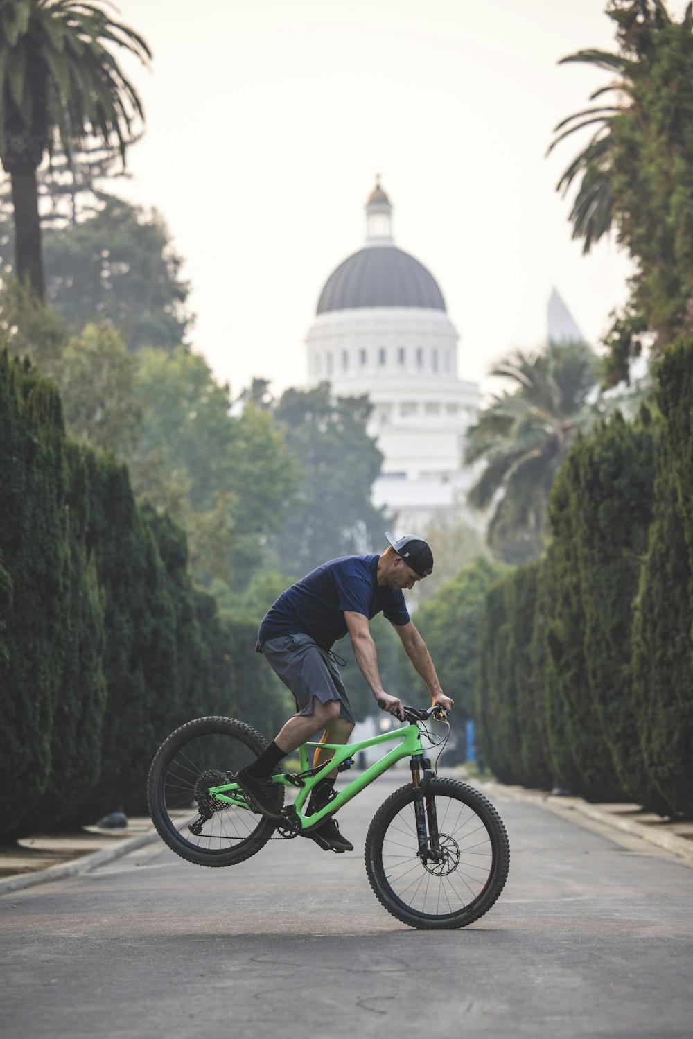 man in blue shirt riding green bmx bike during daytime