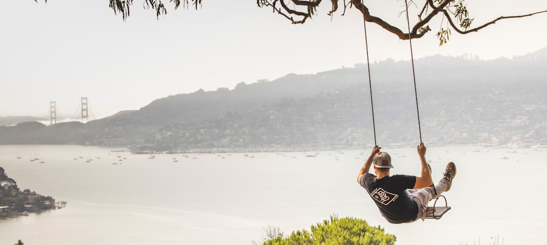 woman in black tank top sitting on swing during daytime