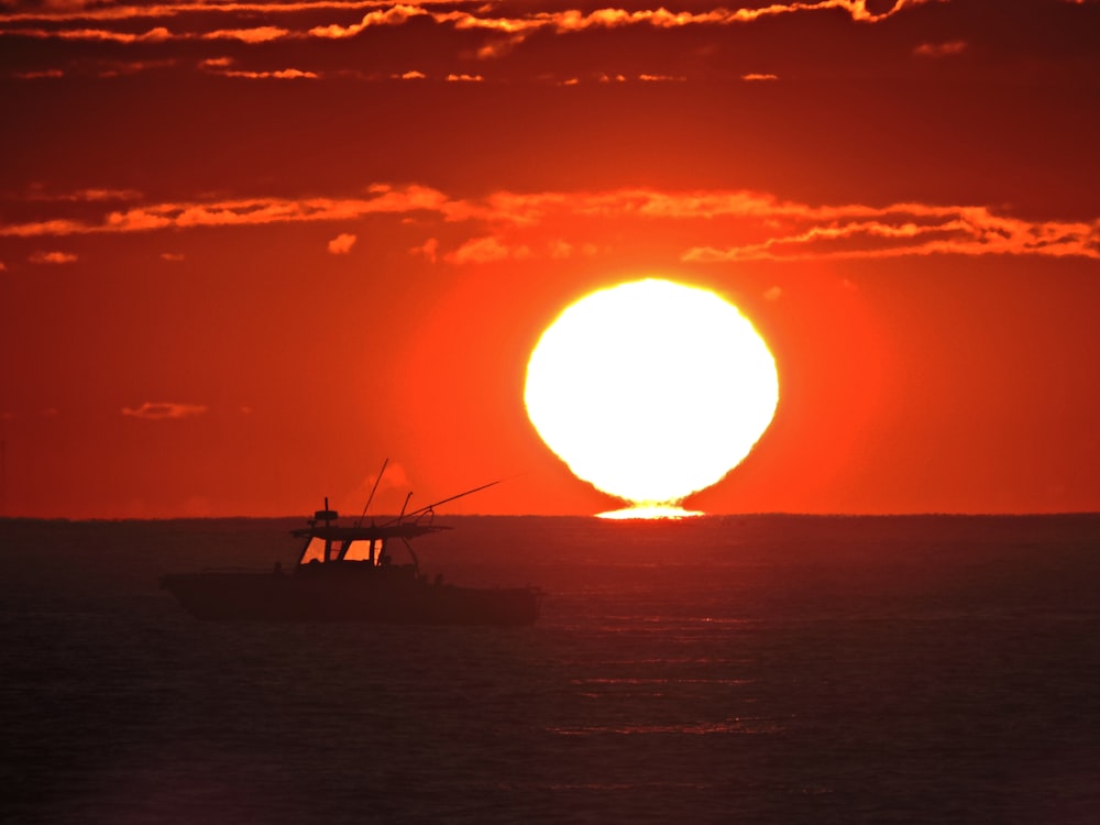 silhouette of person riding on boat during sunset