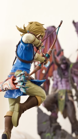 A highly detailed figure of an archer dressed in blue with a quiver full of arrows on their back, aiming a drawn bow. The background presents another figure with purple skin and large, bat-like wings, appearing menacing and mythical.
