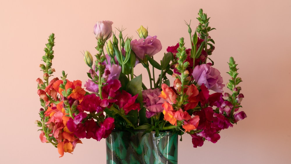 pink and purple flowers in clear glass vase