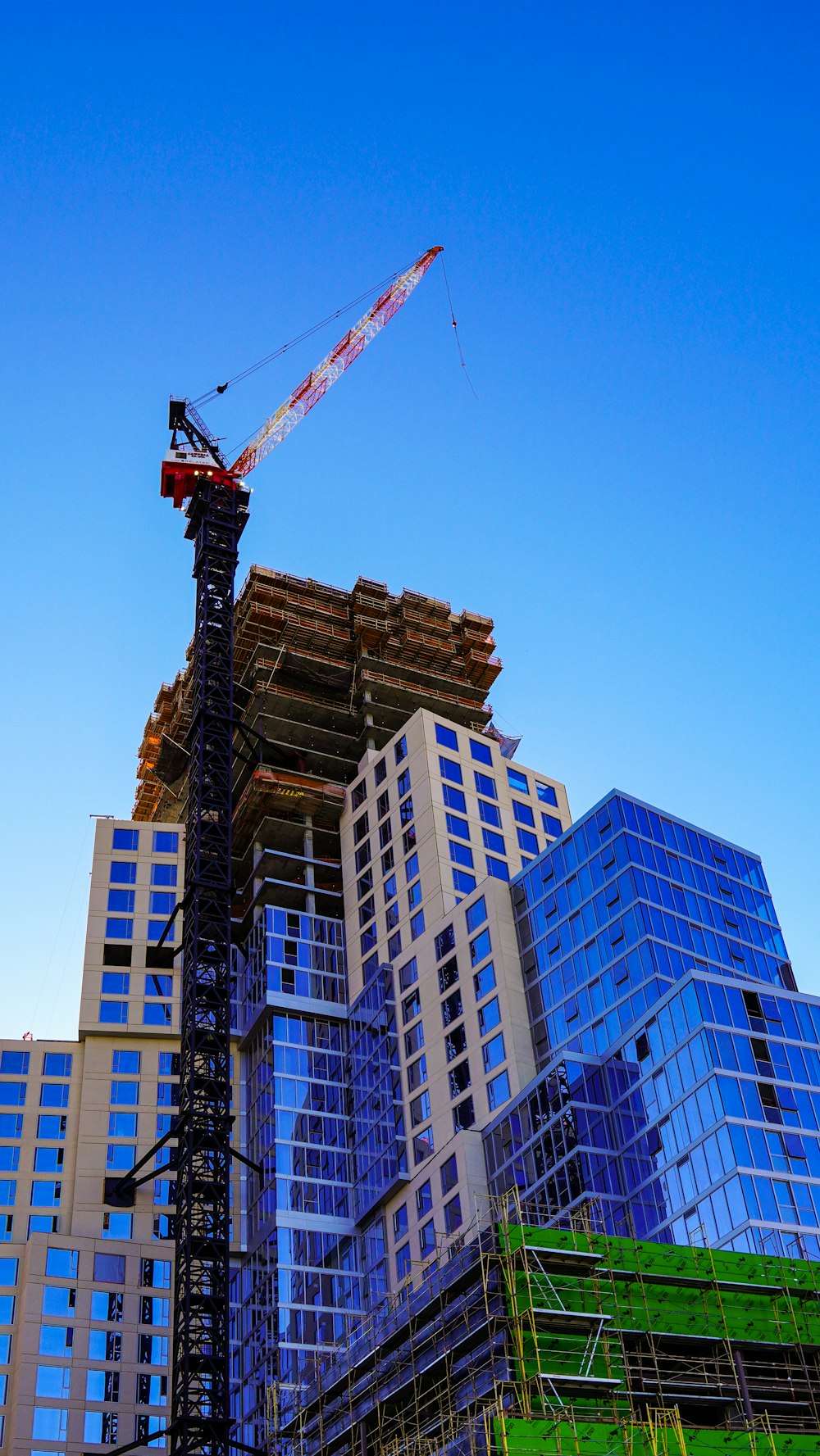 red crane near high rise building during daytime