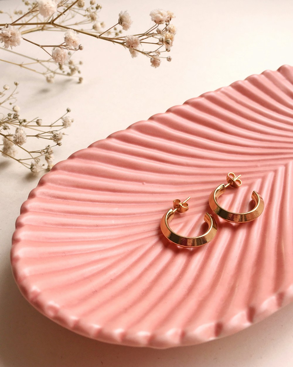Bagues en or et argent sur textile rayé rose et blanc