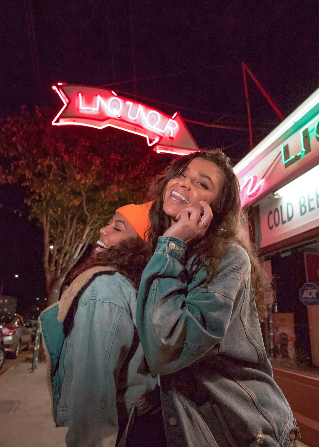 woman in gray coat sitting on chair near store during nighttime