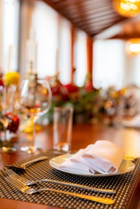 Close-up of hands setting delicate tableware on a cream-colored linen tablecloth.