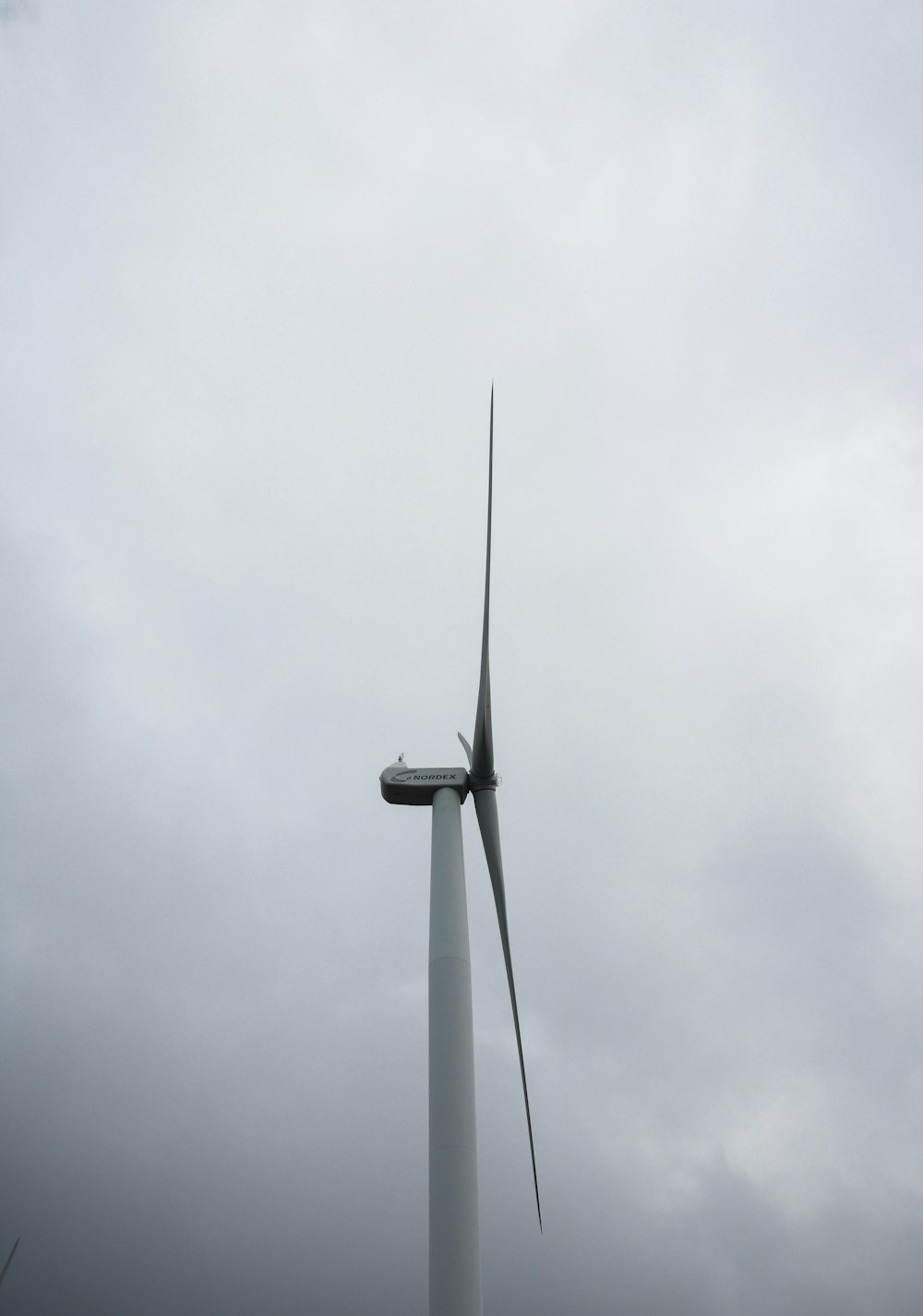 gray wind turbine under gray sky