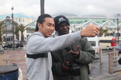 A happy duo taking a selfie together at a lively outdoor market.