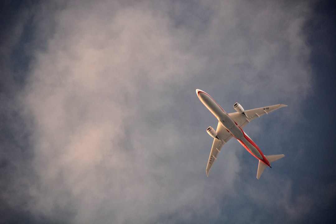 white airplane flying in the sky