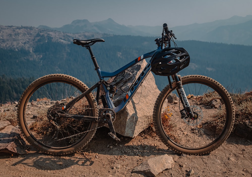 full suspension mountain bike leaning against a rock