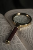A magnifying glass focusing on a globe representing world knowledge.