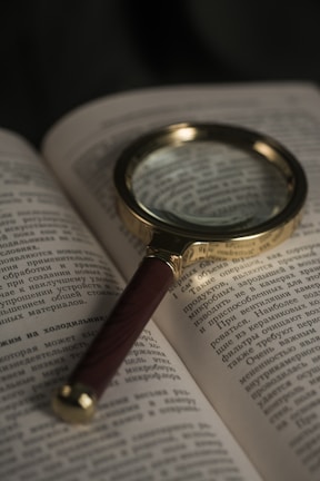 A magnifying glass focusing on a globe representing world knowledge.