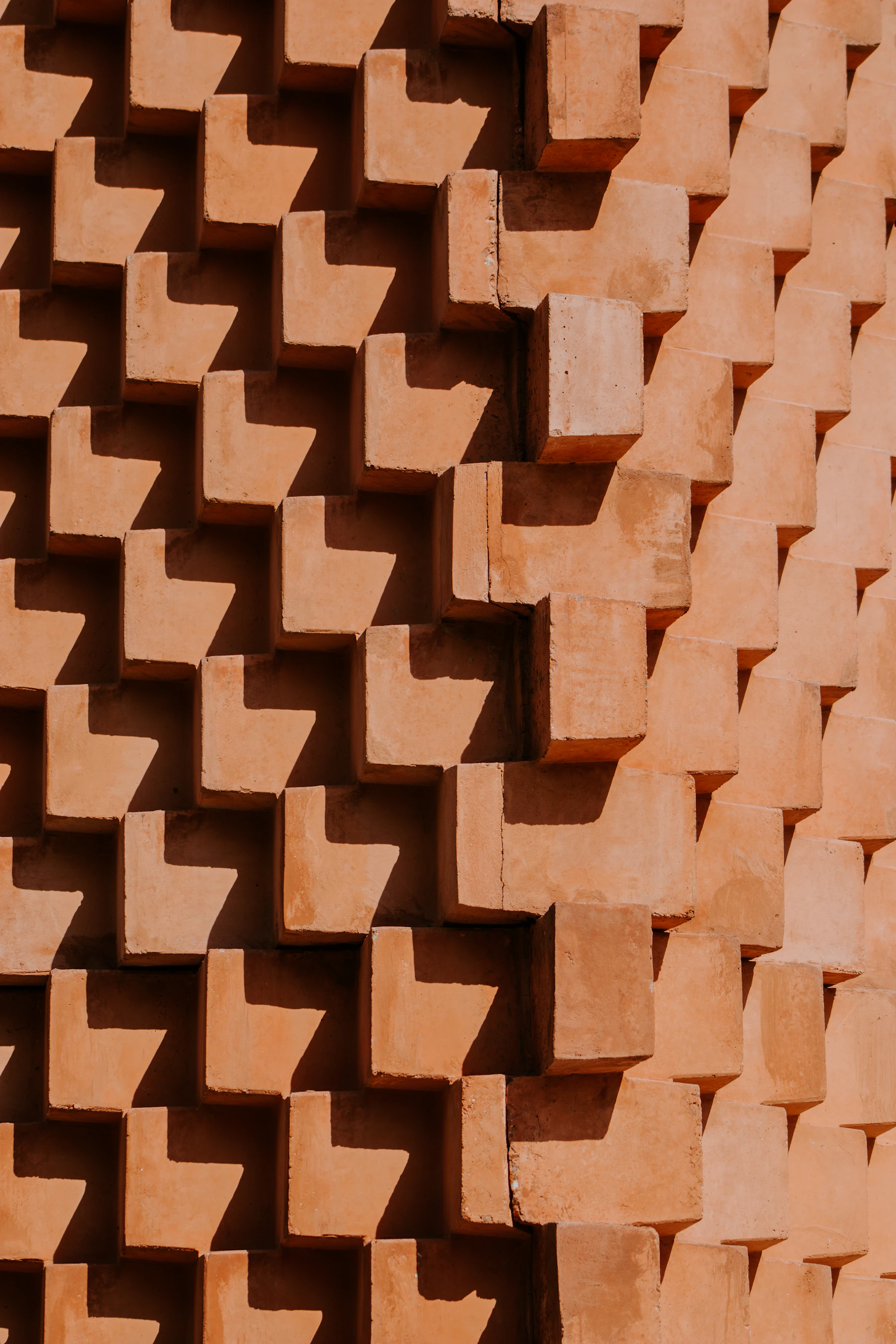 Red bricks stacked in a stepped pattern, deep shadows between them