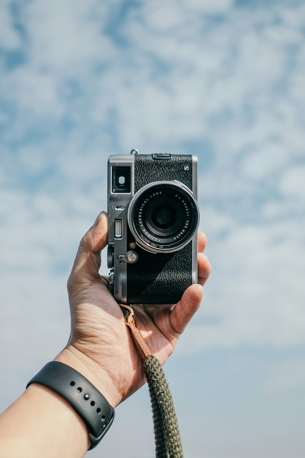 person holding black and silver camera