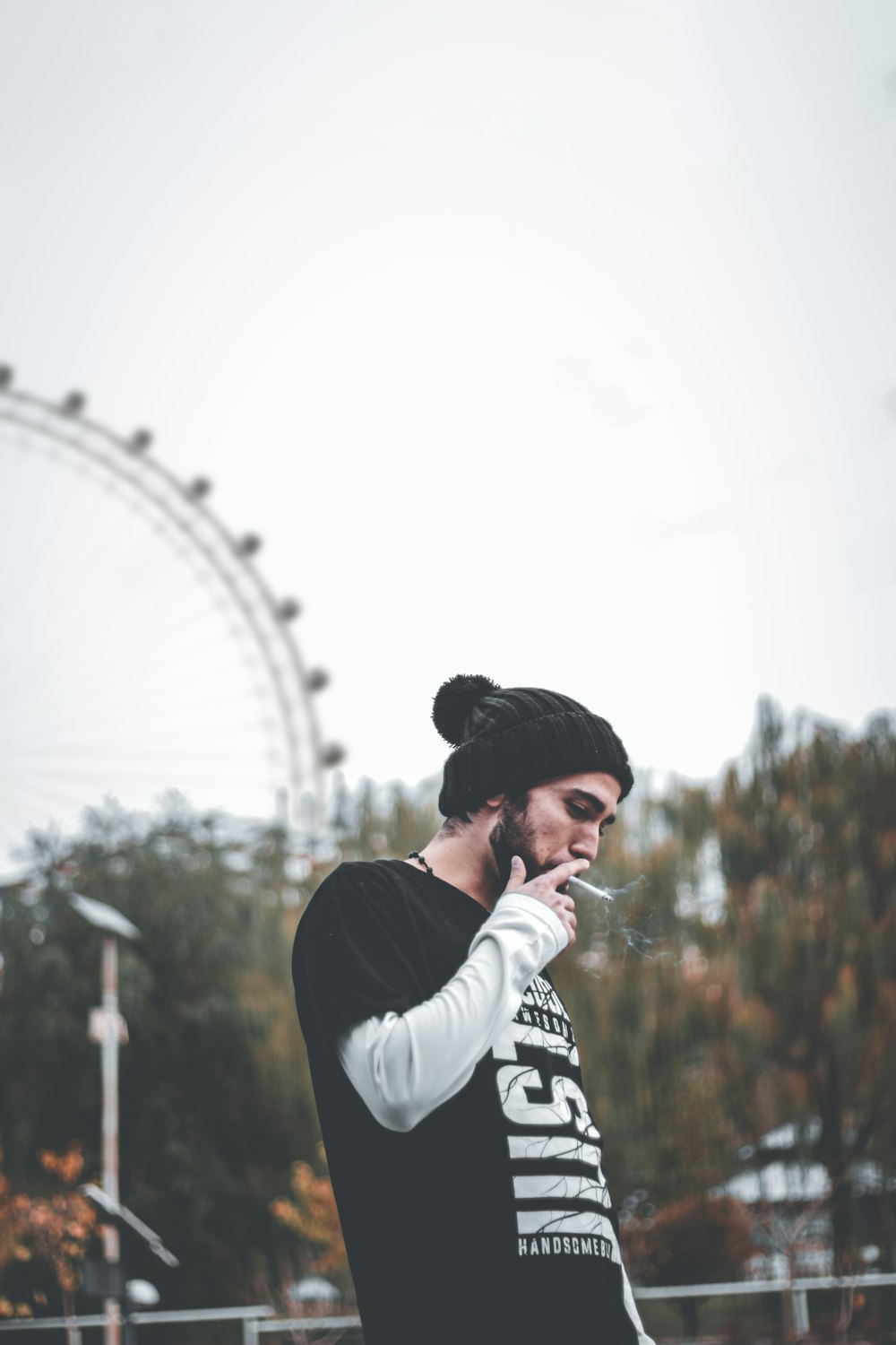 man in black and white hoodie smoking cigarette