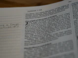 Close-up of an open book showing elegant typography and a handwritten note.