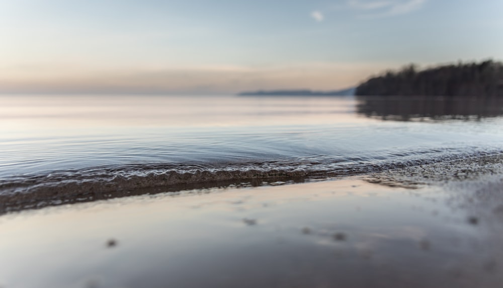 sea waves crashing on shore during sunset