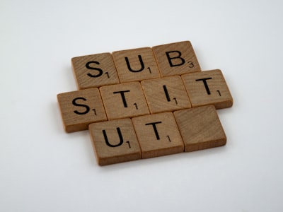 scrabble pieces spelling out substitute
